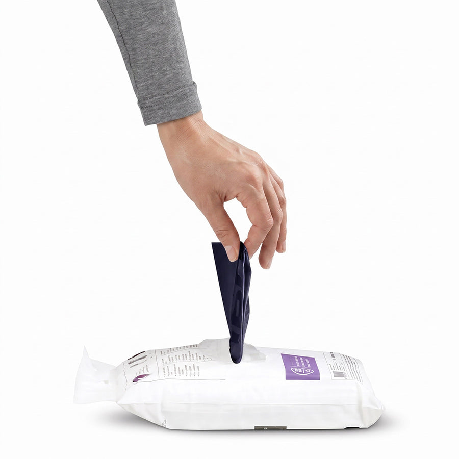 Hand accessing Simplehuman's Nebula Liners through the easy-dispense liner package.
