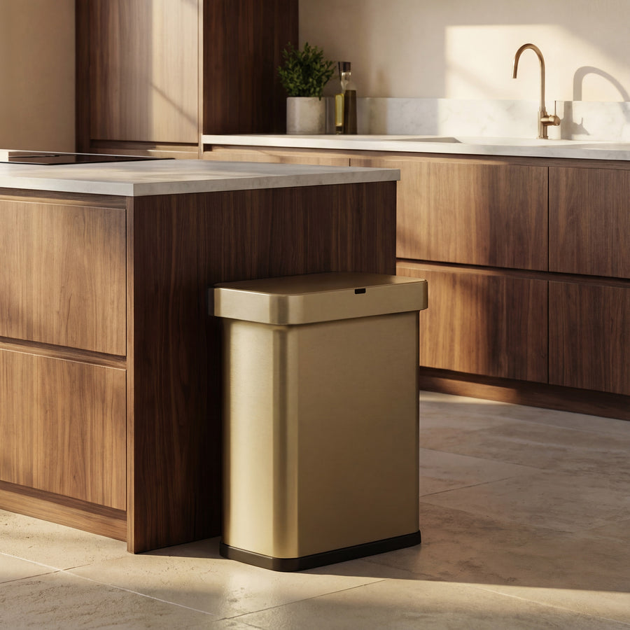Simplehuman's Matte Gold Sensor Can in an elevated kitchen setting with wood, marble counter tops, and brass hardware.