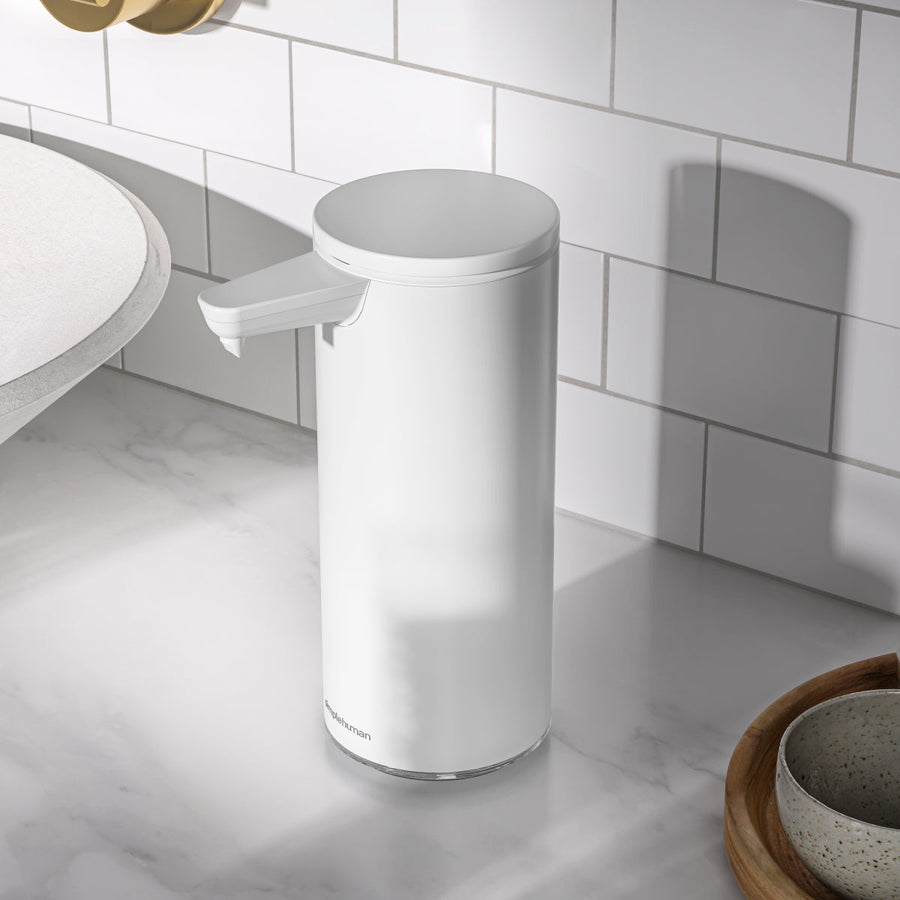 Simplehuman 9 oz. Sensor Pump in White on modern marble counter, rechargeable, touch-free operation.