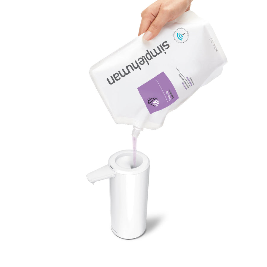 Simplehuman White 9 oz. Rechargeable Sensor Pump being refilled using a pouch, demonstrating the wide, easy-fill opening.