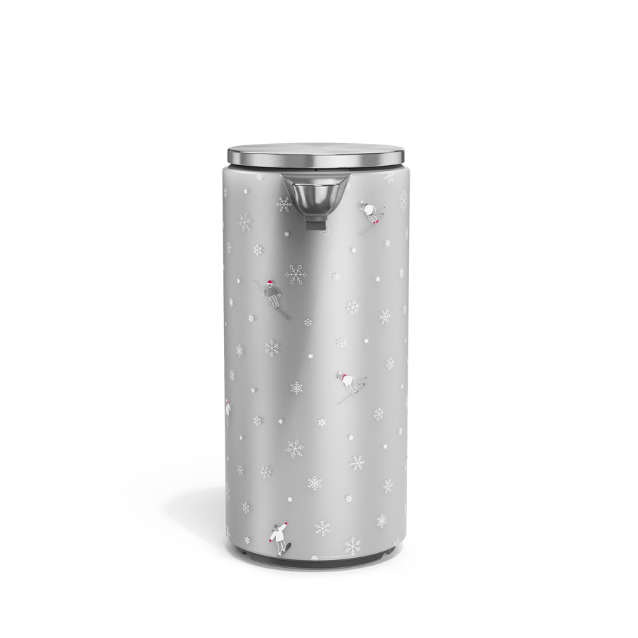 Front view of Simplehuman Brushed 9 oz. Sensor Pump with holiday sleeve. White, frosted sleeve with skiers and snowflakes. 