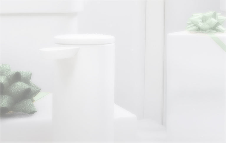 This image features some of Simplehuman's flagship products in a White finish with green ribbons and bows on top with a frosted effect.