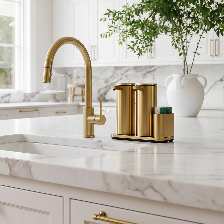 Simplehuman's Dual 14 oz. Sensor Pump in Brass in a modern kitchen setting with marble counter top and white cabinets.