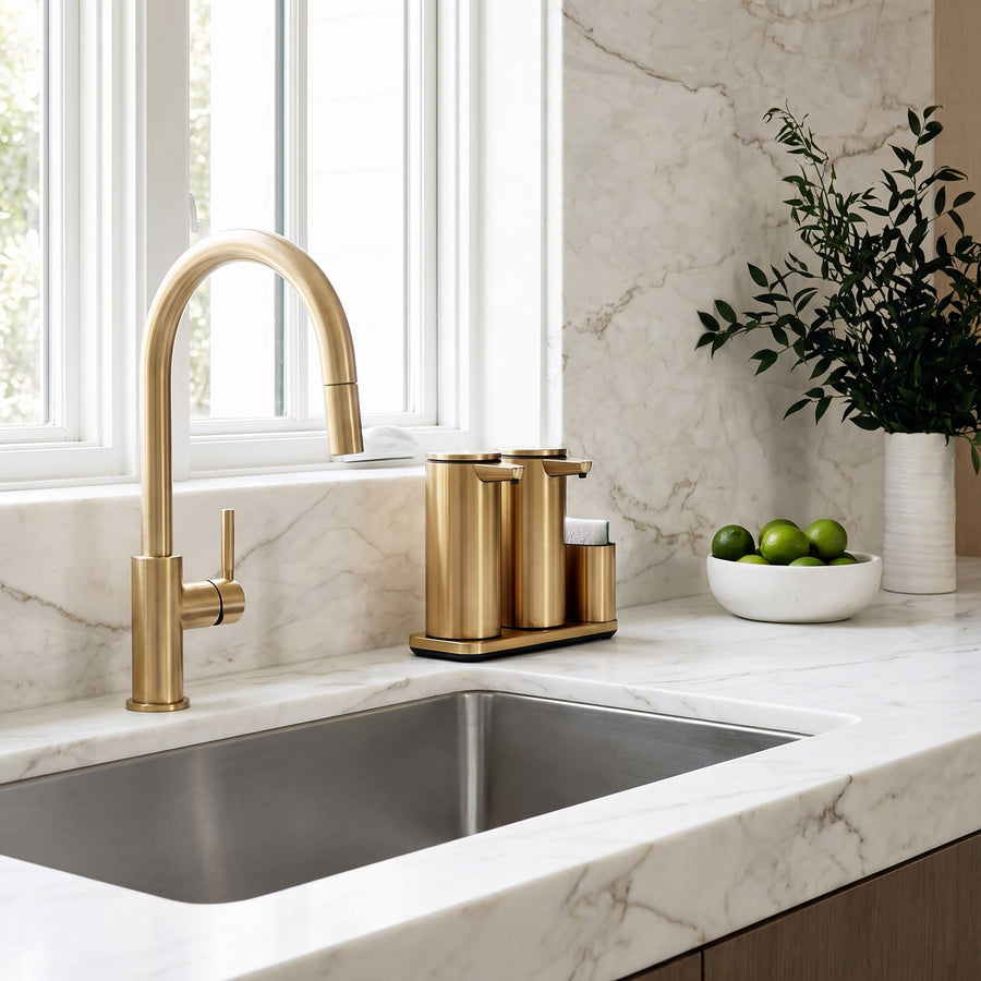 Simplehuman's Dual 14 oz. Sensor Pump in Brass in a modern kitchen setting with marble counter top and wooden cabinets.