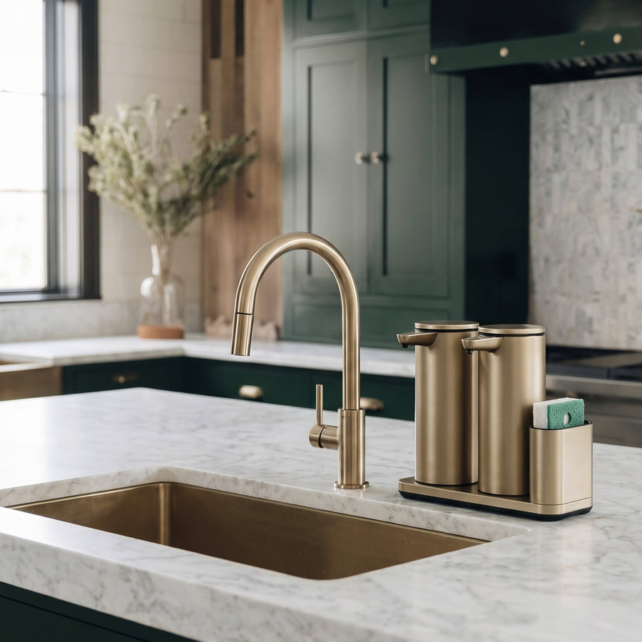Simplehuman's Dual 14 oz. Sensor Pump in Matte Gold in a modern kitchen setting with marble counter top and green cabinets.