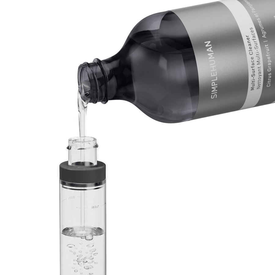 Simplehuman's Refill Bottle filling a Simplehuman Paper Towel Holder with Spray. 