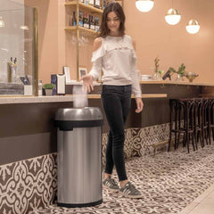 60L semi-round open can - brushed stainless steel - lifestyle woman in cafe throwing trash away