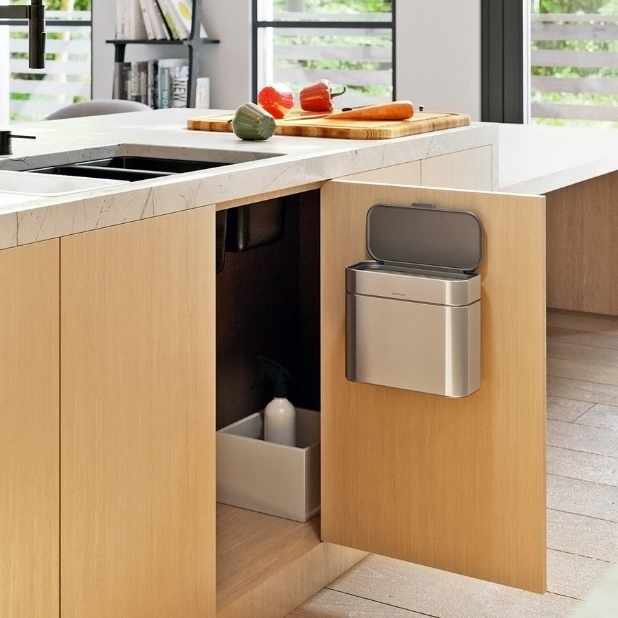 Simplehuman Brushed Stainless Steel Compost Caddy mounted inside a cabinet door for hidden, space-saving composting.